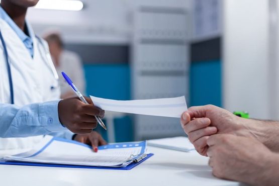 médico entregando receta a paciente